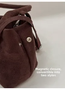 Detail of dark brown suede tote featuring metal snap buttons to change bag shape