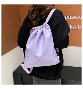 Detail of light purple drawstring backpack showing adjustable straps and fabric texture