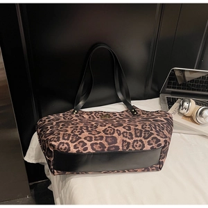 Detail of leopard print tote bag with black leather base and elegant gold metal clasp