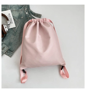 Detailed view of pink water-resistant drawstring backpack with nylon woven straps and buckles
