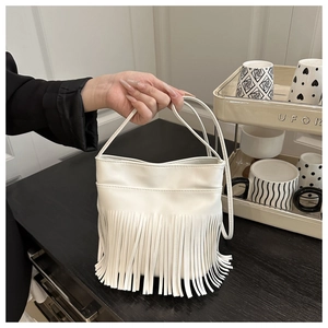 Détail d'un sac à main blanc bohème avec de longues franges et des anses fines