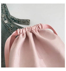 Detailed macro view of pink satin drawstring pouch made of smooth lustrous fabric