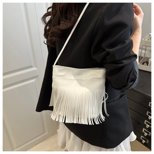 Détail d'un sac bandoulière en cuir PU blanc avec de longues franges verticales et fine bandoulière