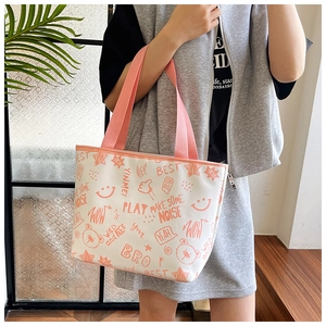 Detail of canvas tote bag with orange graffiti patterns and sturdy woven handles