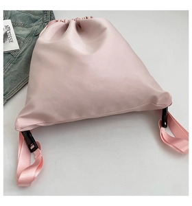 Detail of light pink drawstring backpack with smooth leather texture and nylon straps