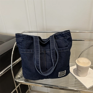 Large capacity dark blue denim tote bag with front pockets and modern stitching details