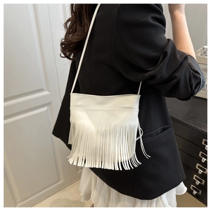 Detailed close-up of a white fringe crossbody bag featuring long tassels and PU leather