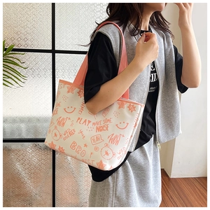 Detail view of the colorful graffiti print and pink woven handles on a canvas tote bag
