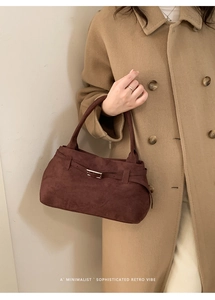 Detail view of a vintage dark brown matte leather tote bag with metal buckle accent