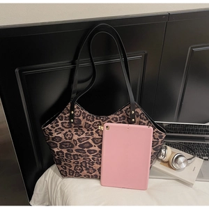 Detail of leopard print tote bag showing large capacity with leather handles and tablet