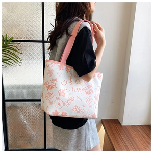 Close-up of white canvas tote bag with pink straps and vibrant graffiti patterns