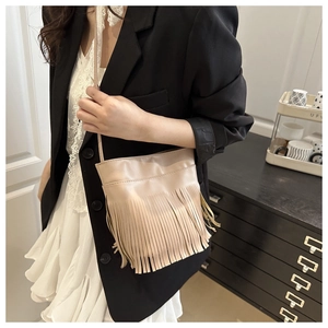 Détail d'un sac à bandoulière beige à franges en similicuir porté par un mannequin