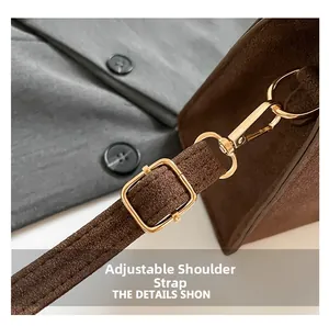 Detail of adjustable golden metal hardware and strap on brown frosted texture bag