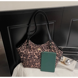 Close-up of leopard print tote bag with gold twist lock and tablet for size comparison