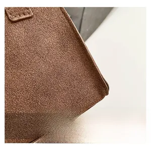 Macro shot of brown frosted suede texture with precise stitching on a Kelly style bag