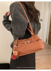 Brown frosted suede tote bag featuring retro metal buckles and colorful pom-pom charm detail
