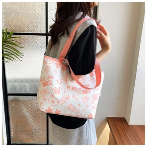 Detail of white canvas tote bag featuring pink cartoon graffiti and sturdy shoulder straps