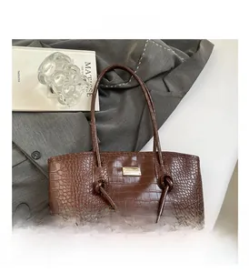 Détail du sac cabas marron foncé avec motif crocodile embossé et finitions dorées