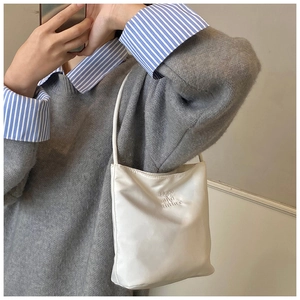 Détail d'un sac bandoulière blanc en PU avec lettrage Hope and Future gaufré sur la surface