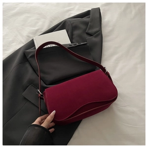 Detail shot of wine red matte leather shoulder bag with adjustable silver buckle strap