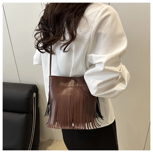 Détail du sac en daim marron avec de longues franges et une fine bandoulière