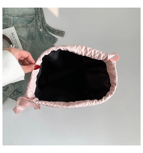 Top view of pink drawstring bucket bag showing spacious black interior and silk texture