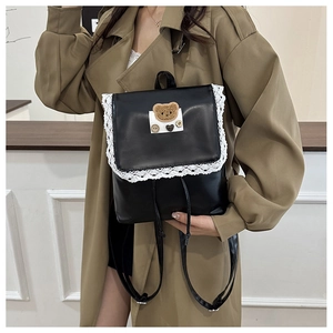 Detail showing the lace trim and vintage bear embroidery on this black PU leather backpack