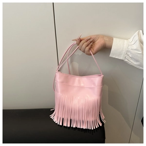 Close-up detail of soft pink crossbody bag with long fringes and smooth faux leather texture
