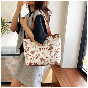Detail of white tote bag with brown doodle prints and cute bear graphics