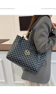 Detail of large tote bag showing M-pattern print and golden metal chain handle