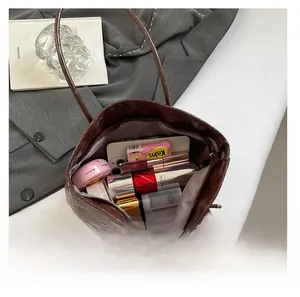 Vue intérieure d'un grand sac cabas marron à motif crocodile rempli d'objets du quotidien