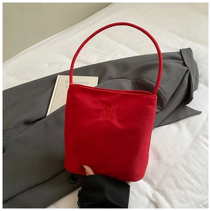 Gros plan sur un sac seau en toile rouge avec broderie Hope and future et anses fines