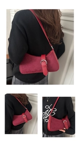 Detail of dark red suede moon bag featuring a silver circular buckle and retro shoulder strap