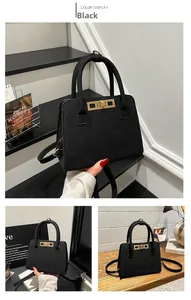 Detail view of black vintage frosted handbag featuring golden twist lock and twin handles