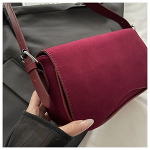 Close-up of vintage burgundy suede shoulder bag showing rich texture and silver metal hardware
