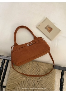 Detail of caramel brown matte tote bag showing suede texture and silver metal buckle