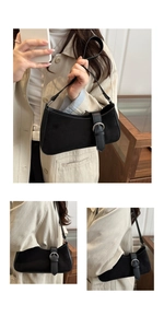 Detail of black baguette shoulder bag with silver round buckle and textured finish