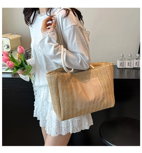 Close-up of woven straw tote bag with cotton rope handles shown on a shoulder model