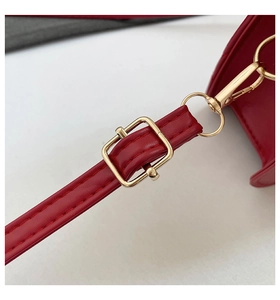 Detailed macro view of red leather strap with premium gold metal buckles and stitching