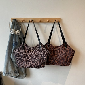 Chic leopard print tote bag with black leather handles and elegant gold metal lock