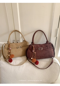 Detail of retro suede tote bags in khaki and chocolate colors with colorful pompom charm