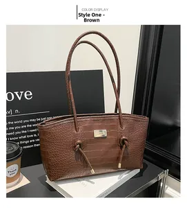 Détail d'un sac cabas marron avec texture crocodile et logo en métal chic