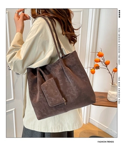 Detail view of large dark brown suede tote bag with matching pouch on model