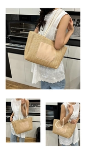 Close-up of beige woven tote bag with white cotton handles and leather patch detail