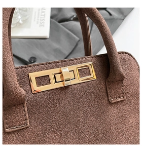 Detail of vintage brown frosted leather bag showing gold rectangular twist lock closure