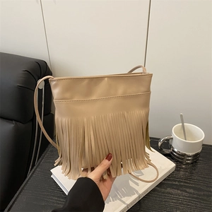 Minimalist beige tassel shoulder bag with bohemian fringe detail and long crossbody strap