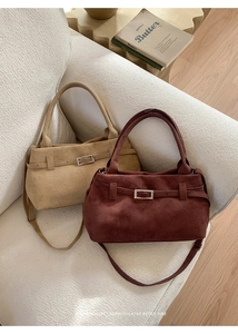 Detail of vintage suede tote bags with metal buckle straps and cylindrical handles