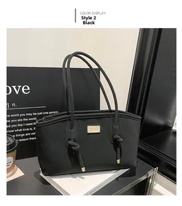 Gros plan sur un sac à bandoulière noir matelassé avec nœuds et plaque logo métallique