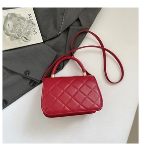 Close-up of red quilted leather handbag with gold hardware and elegant top handle