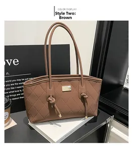 Détail du sac cabas matelassé marron avec bandoulière à nœud et logo doré élégant